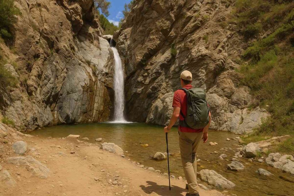 A scenic photograph of a hiker exploring the rugged terrain along the Eaton Canyon Falls, surrounded by natural beauty, clear skies, and dramatic landscapes.