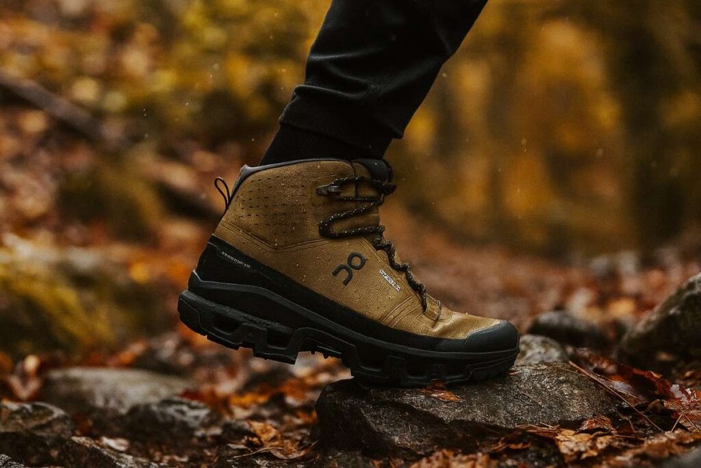 On Cloudrock 2 Waterproof hiking boot with lightweight design crossing wet alpine terrain.