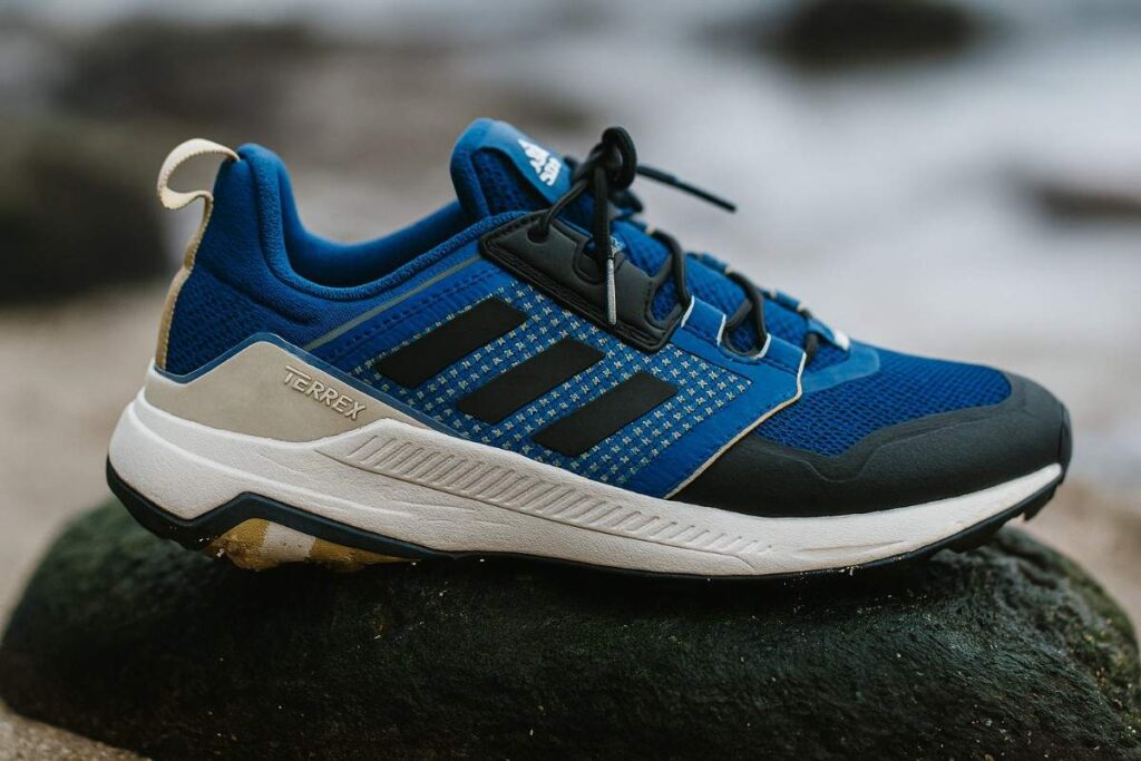 Adidas Terrex Trailmaker close-up on slick mossy coastal foothill rock with water beads on the outsole.