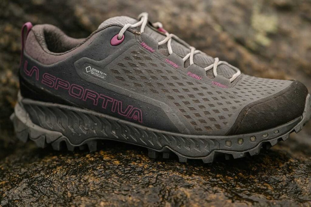 La Sportiva Spire GTX hiking shoes on wet granite rock with visible water droplets.