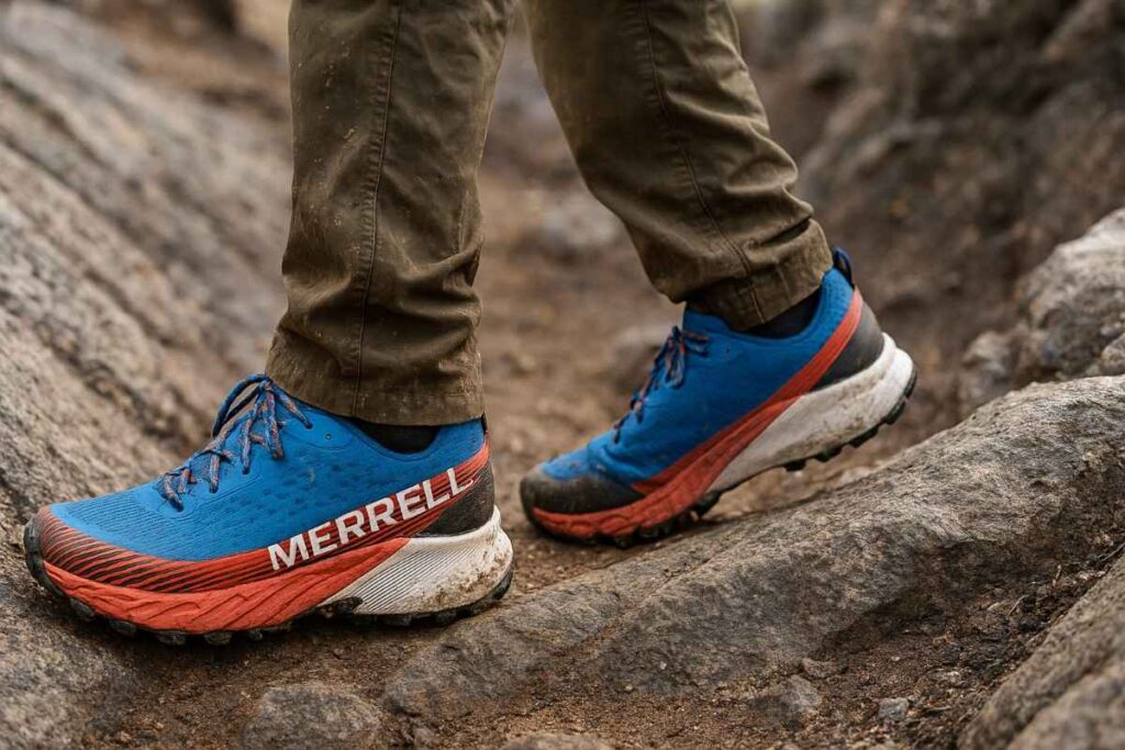 Hiker wearing Merrell Agility Peak 5 running shoes on loose rocky singletrack in Colorado high country.