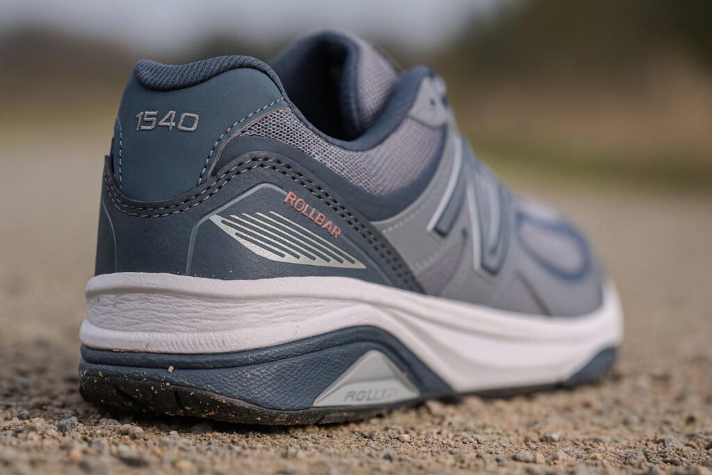 New Balance 1540 medial post close-up on compacted gravel — motion-control stability for plantar fasciitis.