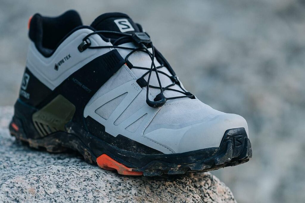 Salomon X Ultra 4 Low outsole close-up on granite and loose scree — technical traction for PF hikers.