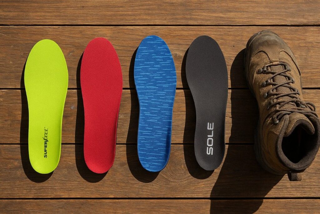 Best insoles for hiking displayed on wooden table with hiking boots nearby.