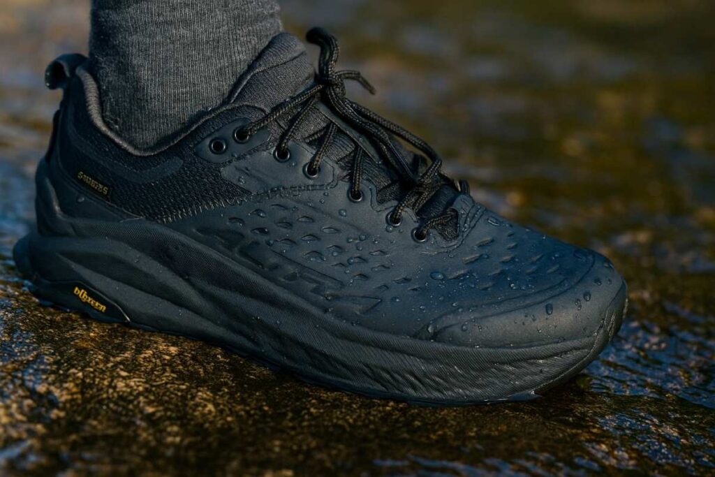 Close-up of Altra Olympus 6 Hike Low GTX shoes gripping wet granite rock.