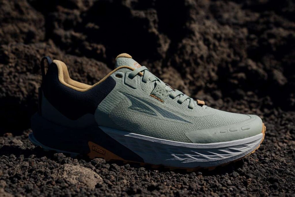 Close-up of Altra Timp 5 shoes on loose volcanic gravel trail.