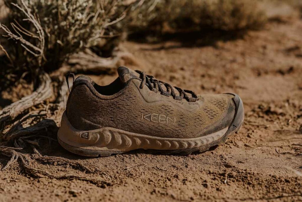 Close-up of KEEN NXIS Speed shoes on a gritty desert trail.
