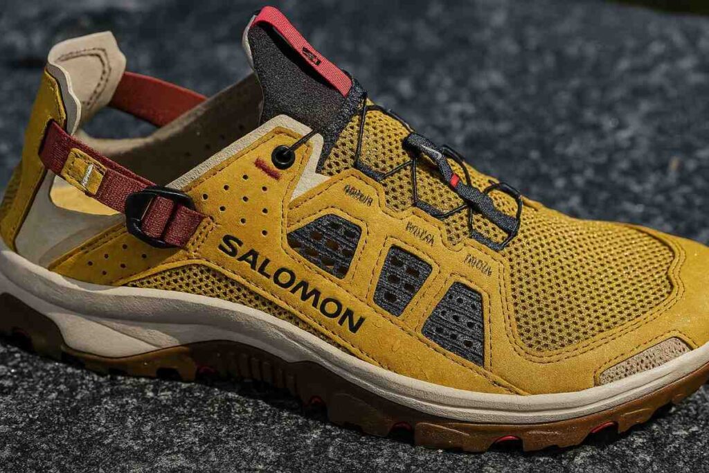 Close-up of Salomon Techamphibian 5 water shoes with drainage ports on wet granite.