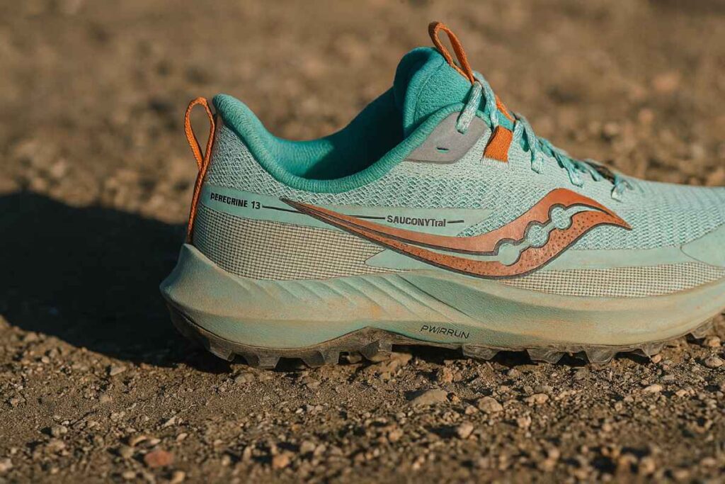 Saucony Peregrine 13 women’s trail running shoes close-up on packed dirt trail.