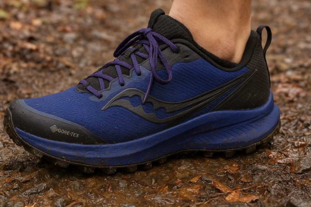 Saucony Peregrine 15 GTX waterproof trail running shoes on damp gravel and mud close-up.