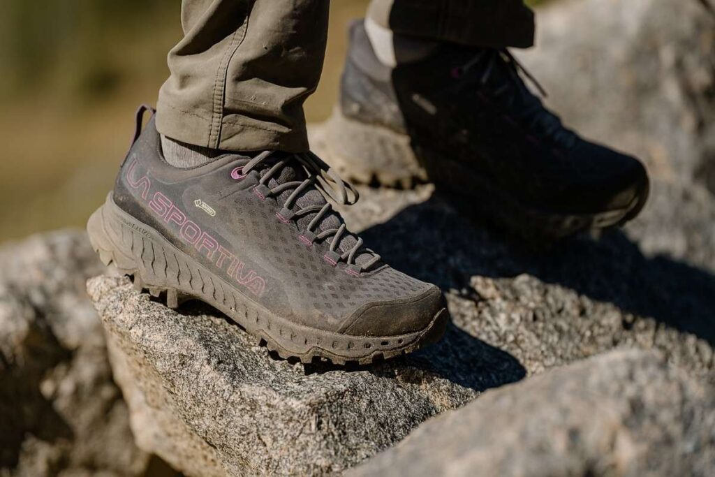 Close up of hiker wearing La Sportiva Spire GTX and standing on rocky surface.