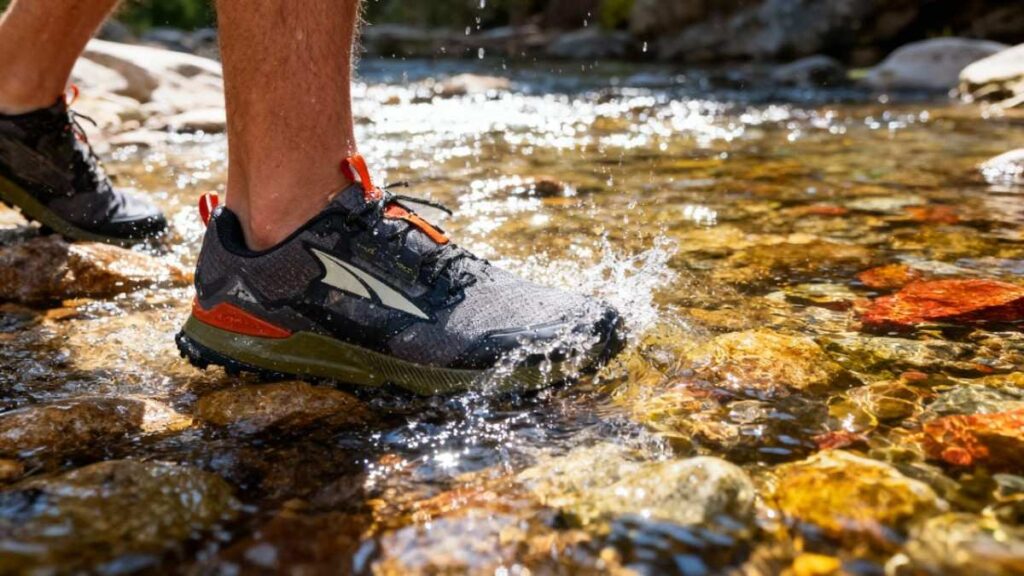 Legs only shot of hiker crossing water stream while wearing Altra Lone Peak 7.