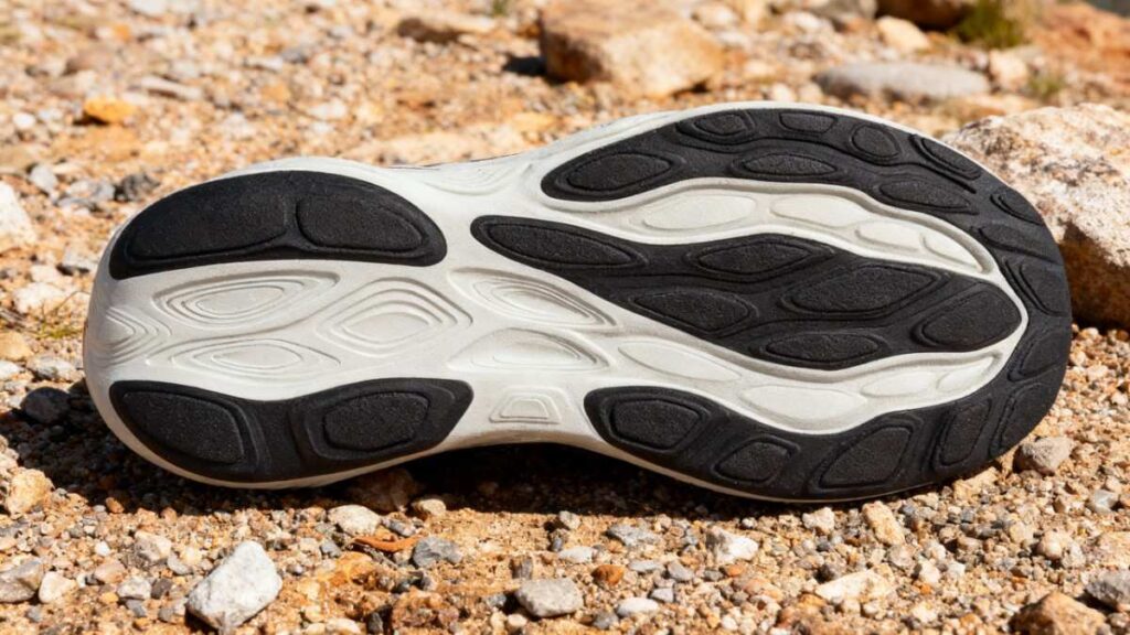 Outsole of New Balance Fresh Foam X 1080 v14 placed on a subtly rocky surface.