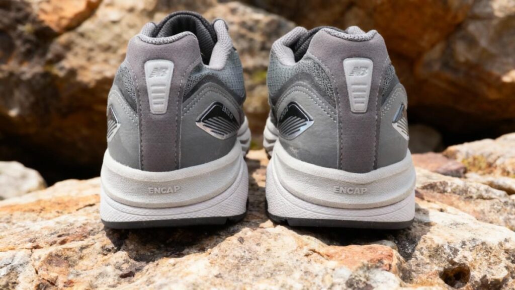 Heel view of New Balance 1540v3, placed on rocks.