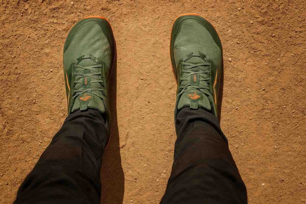 Legs shot of hiker wearing Altra Lone Peak 8 standing on a dirt trail.