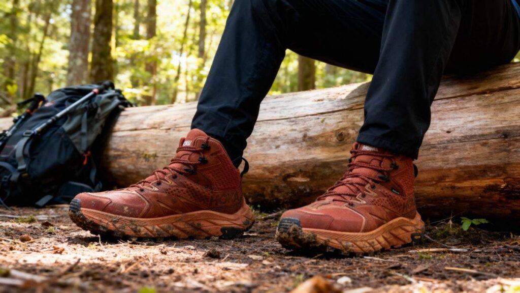 Legs shot of Hiker sitting on a log with HOKA Anacapa Mid GTX in his feet.