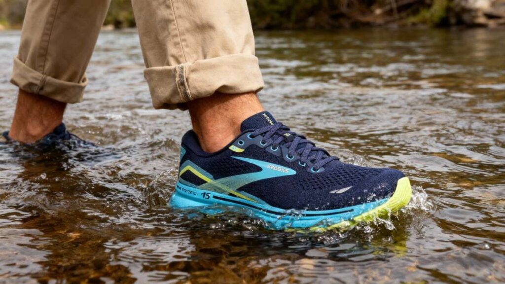 Hiker crossing water stream with Brooks Ghost 15.