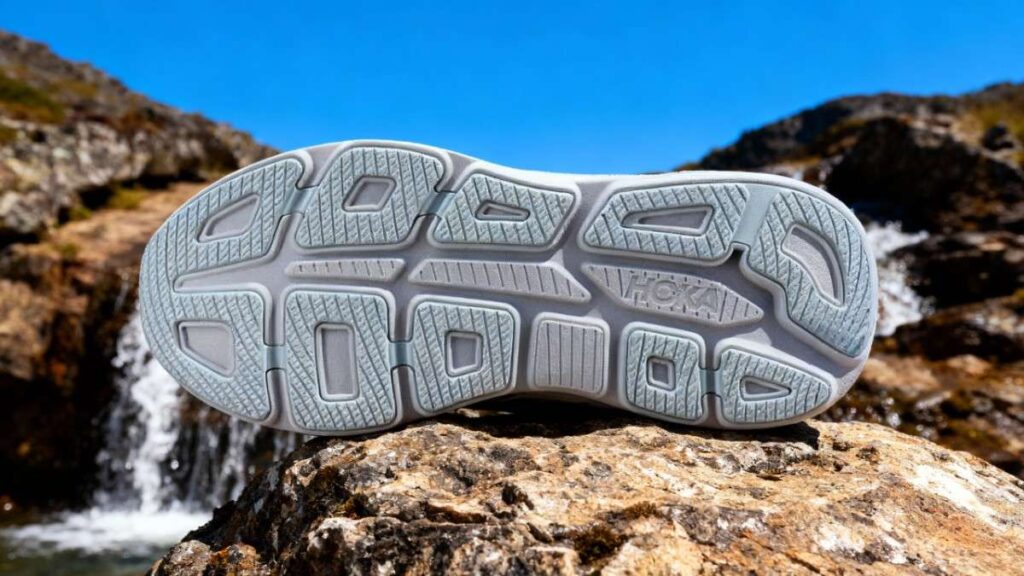 Outsoleof HOKA Bondi 9 displayed on a rock with water stream in background.