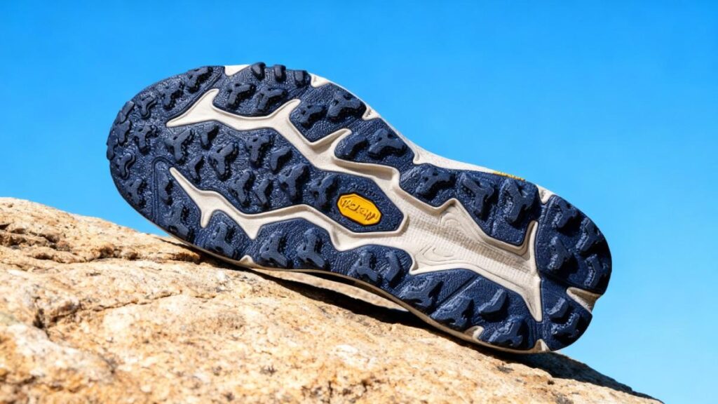Outsole of HOKA Speedgoat 6 displayed on a rock surface.