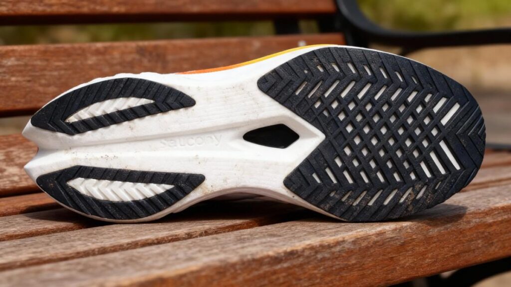 Outsole of Saucony Endorphin Speed 4 placed on a wooden bench.