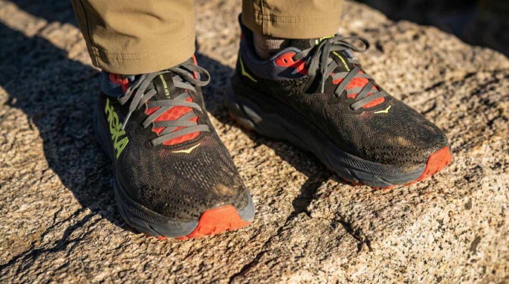 Above angle close-up of HOKA Challenger 7 in hiker's legs. 