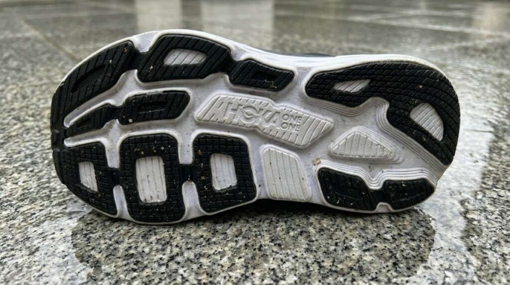 Outsole of Hoka Bondi 7 placed on a wet granite floor. 