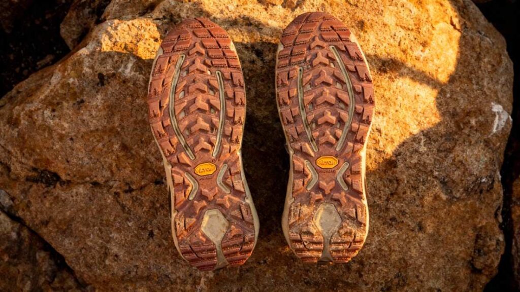 Outsole of Hoka Kaha 3 GTX placed on rock.