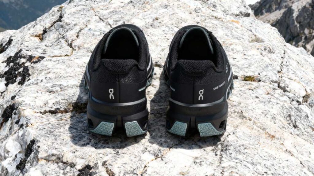 Heels view of On Cloudventure placed on a rocky mount surface.