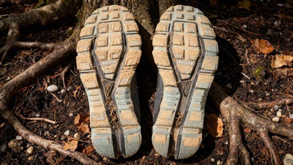 Outsole of On Cloudventure placed on a rooty trail.