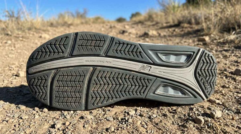 Outsole of New Balance 928v3 placed on a muddy terrain. 